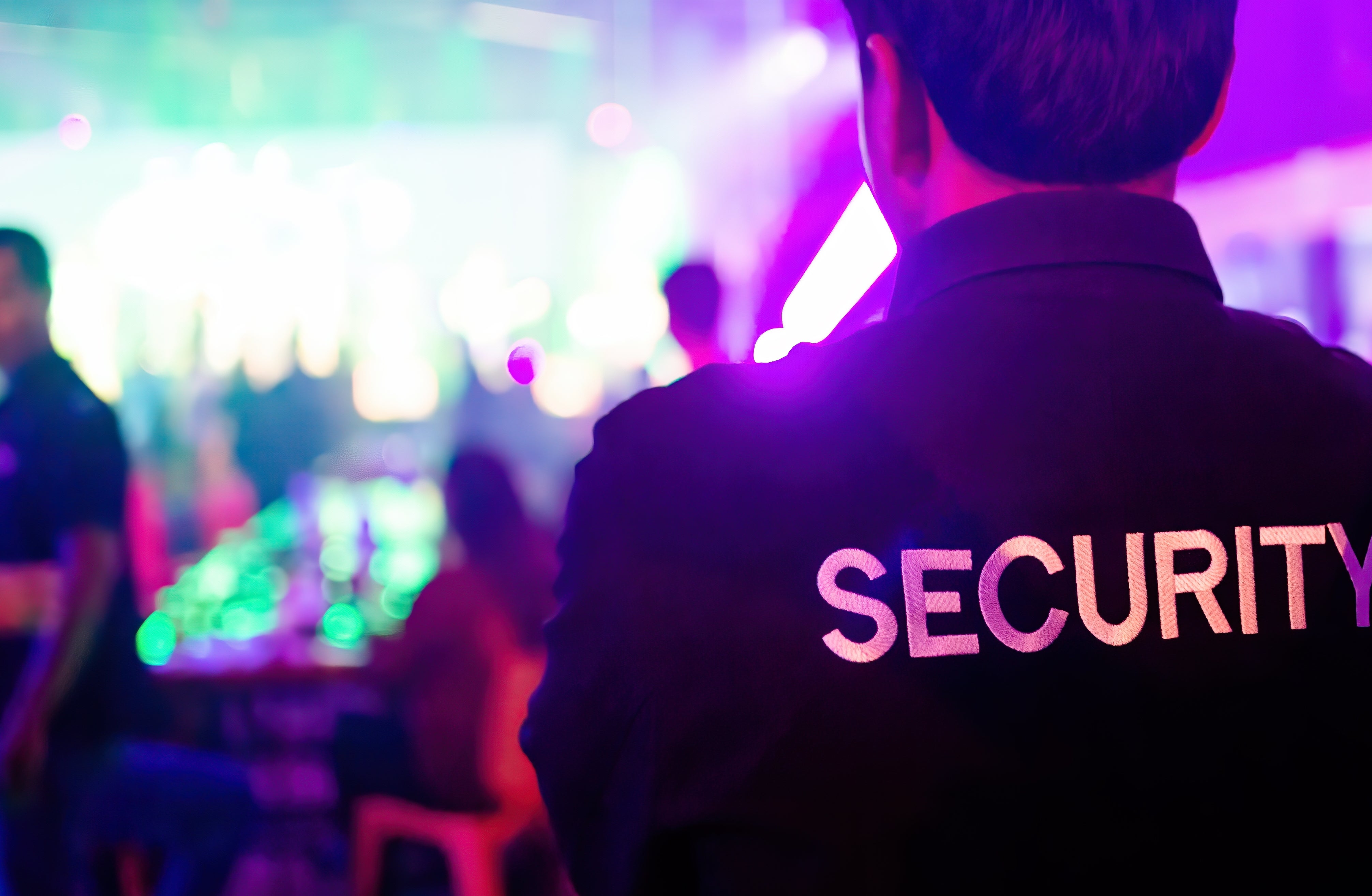 A security guard monitors a crowded event, ensuring safety and order