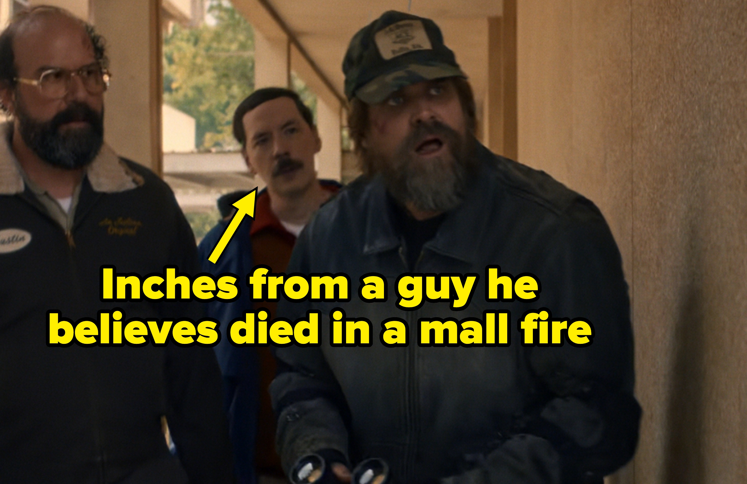 Three men in casual attire, one holding binoculars, appear surprised while looking up outside a building