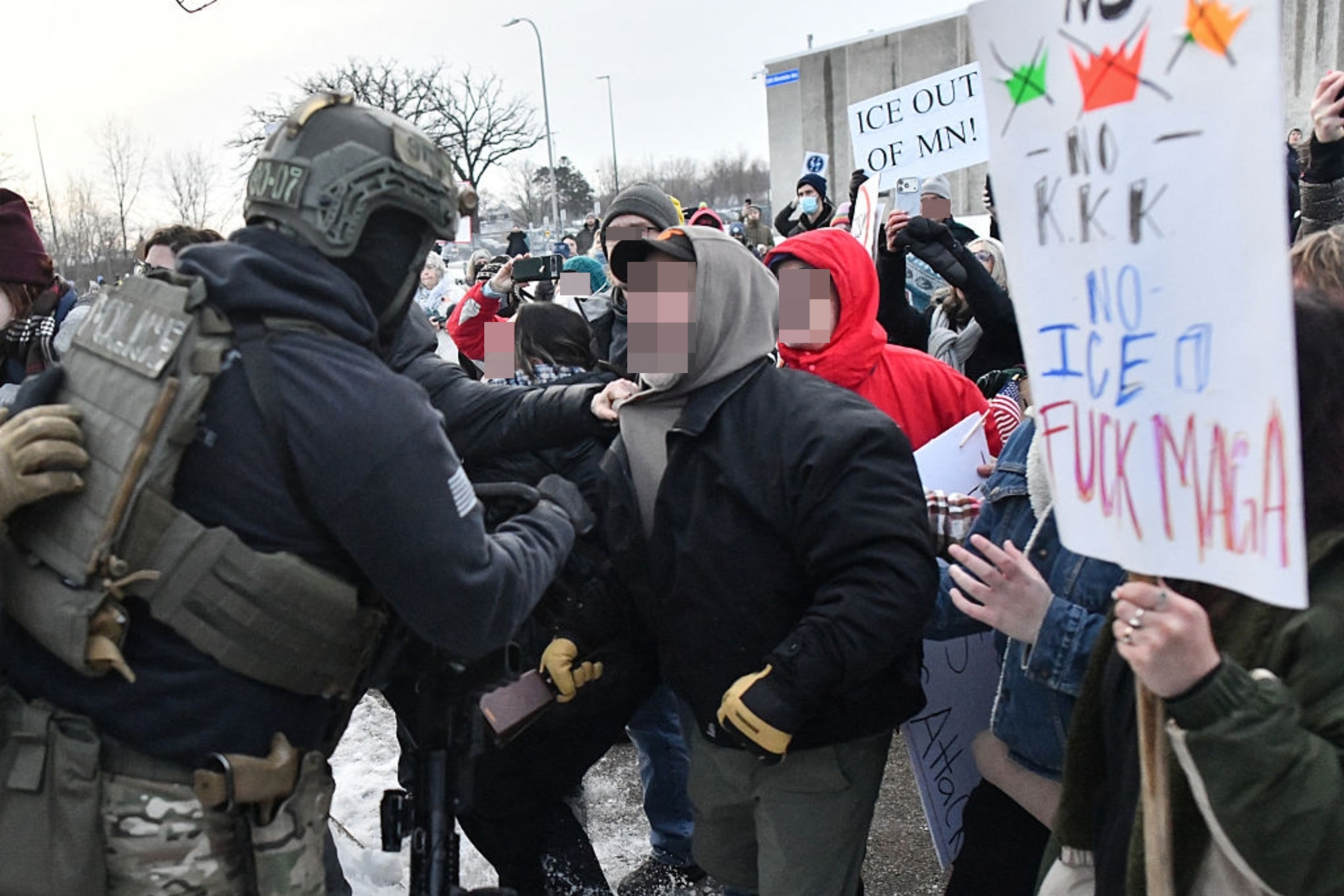 Demonstranter konfronterer en politimann og holder skilt med antirasistiske og anti-ICE-meldinger. Folkemengder uttrykker sterke følelser i en offentlig demonstrasjon