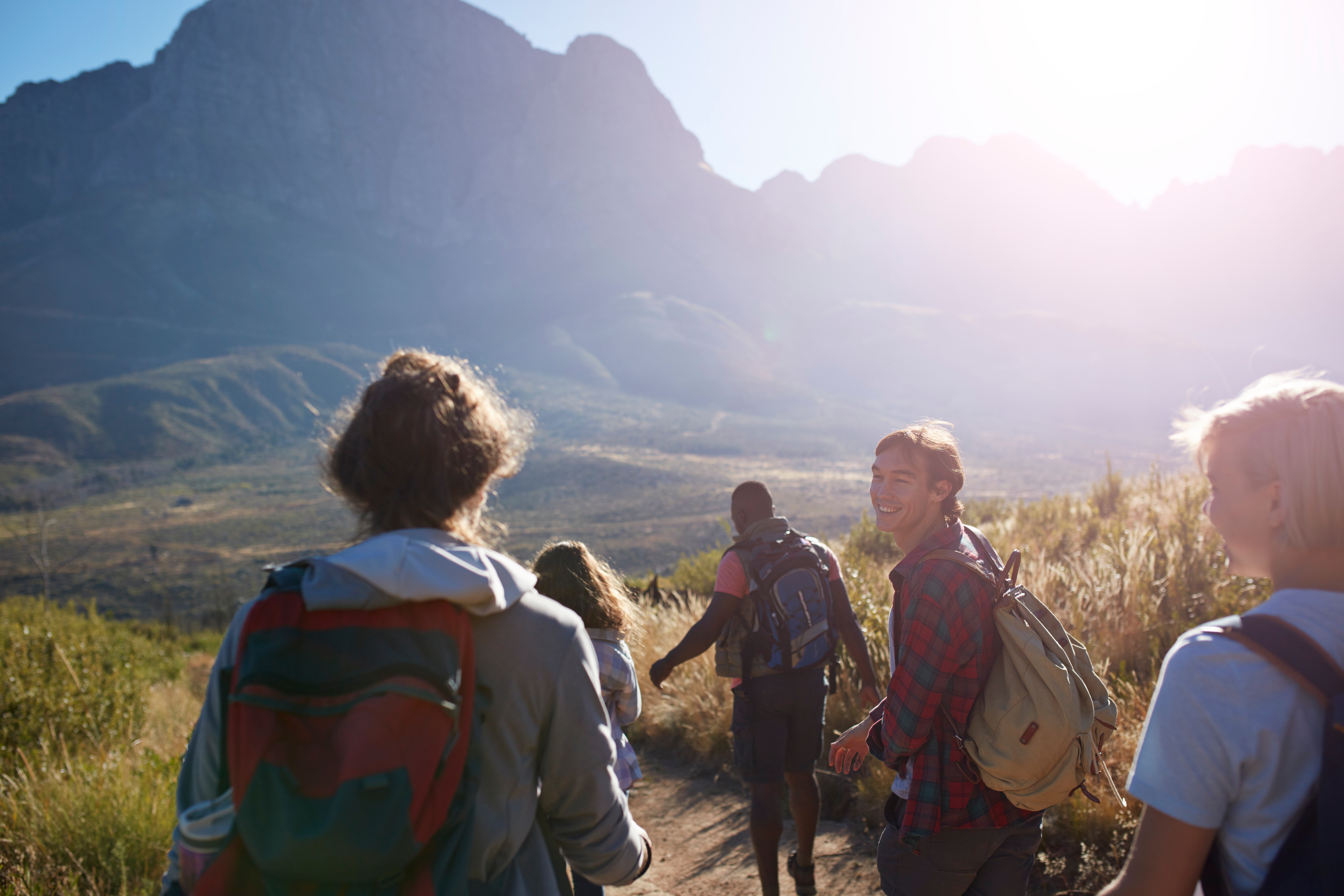 Group of friends hiking connected  a way   with mountains successful  the background, enjoying the sunny day