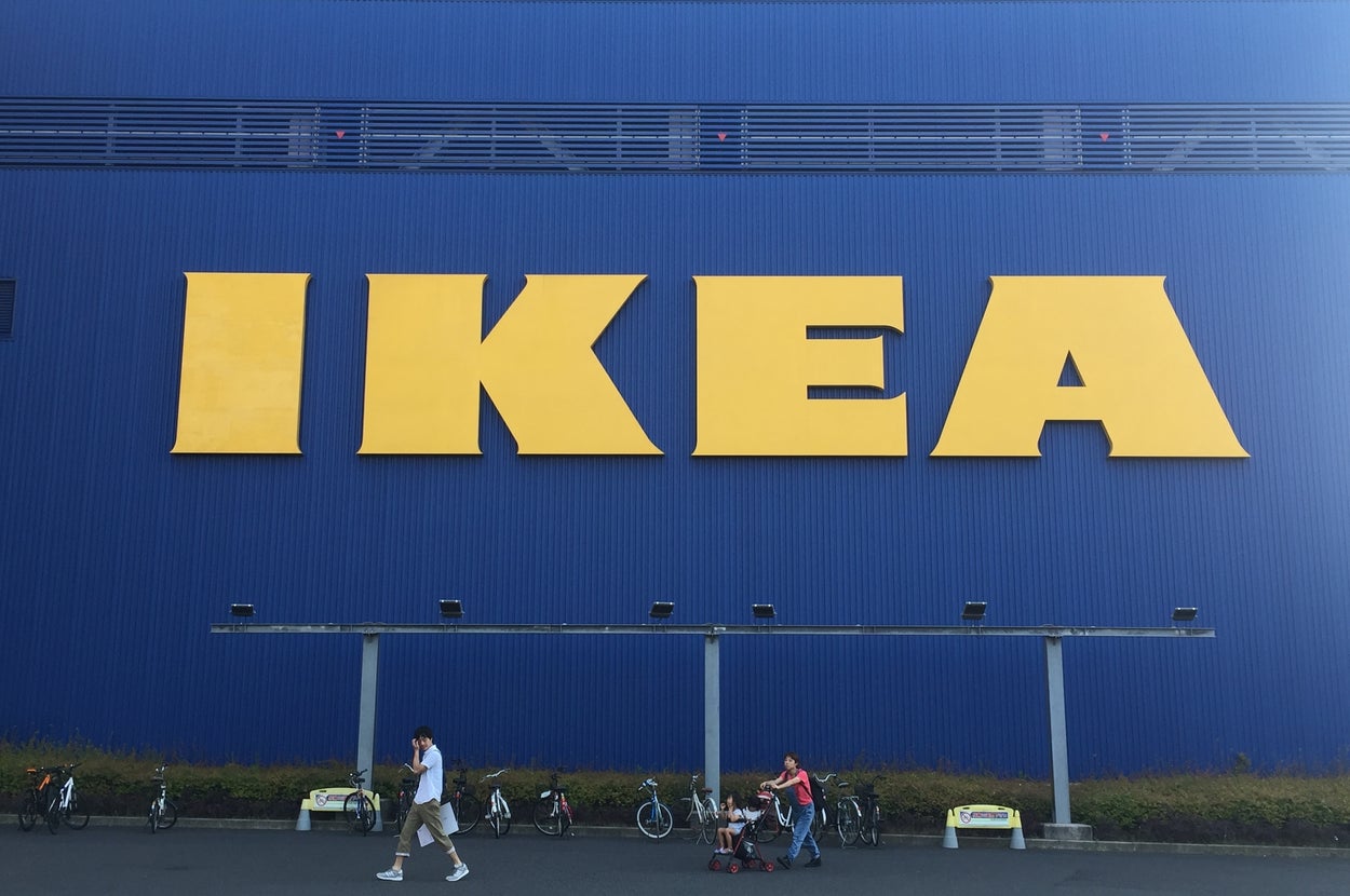 IKEAの店舗外観。人々が歩いている前に大きな「IKEA」の看板がある。