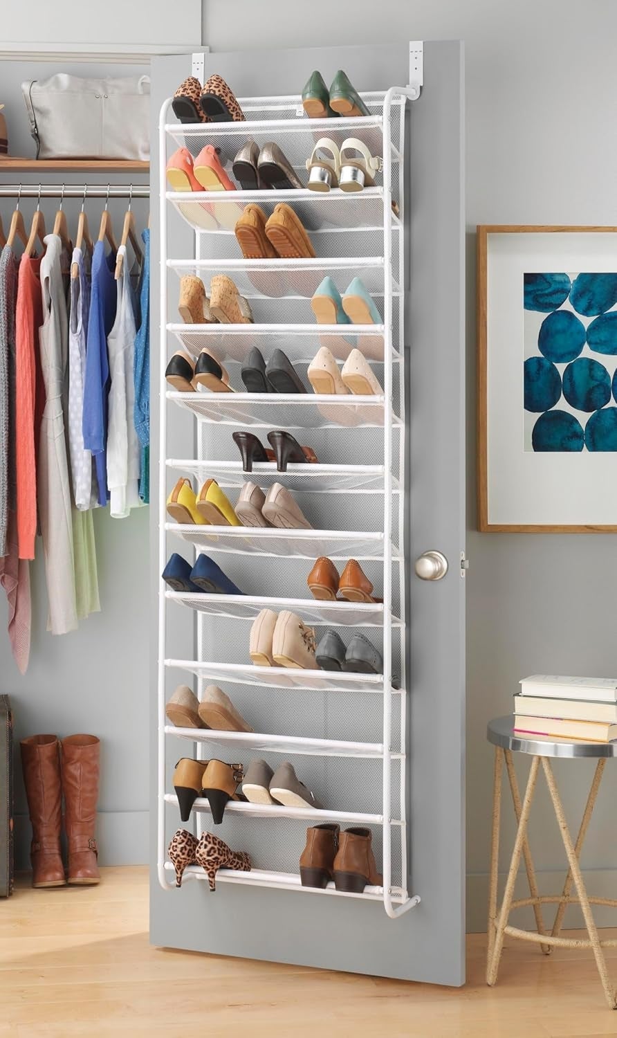 Over-the-door footwear  rack with galore  pairs of shoes neatly organized, placed successful  a closet abstraction  with hanging apparel  and a framed abstract artwork