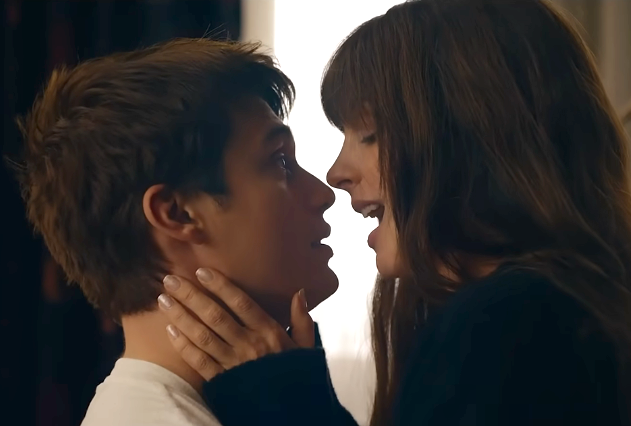 A couple shares an intimate moment, gazing into each other's eyes. The woman gently holds the man's face, suggesting a romantic connection