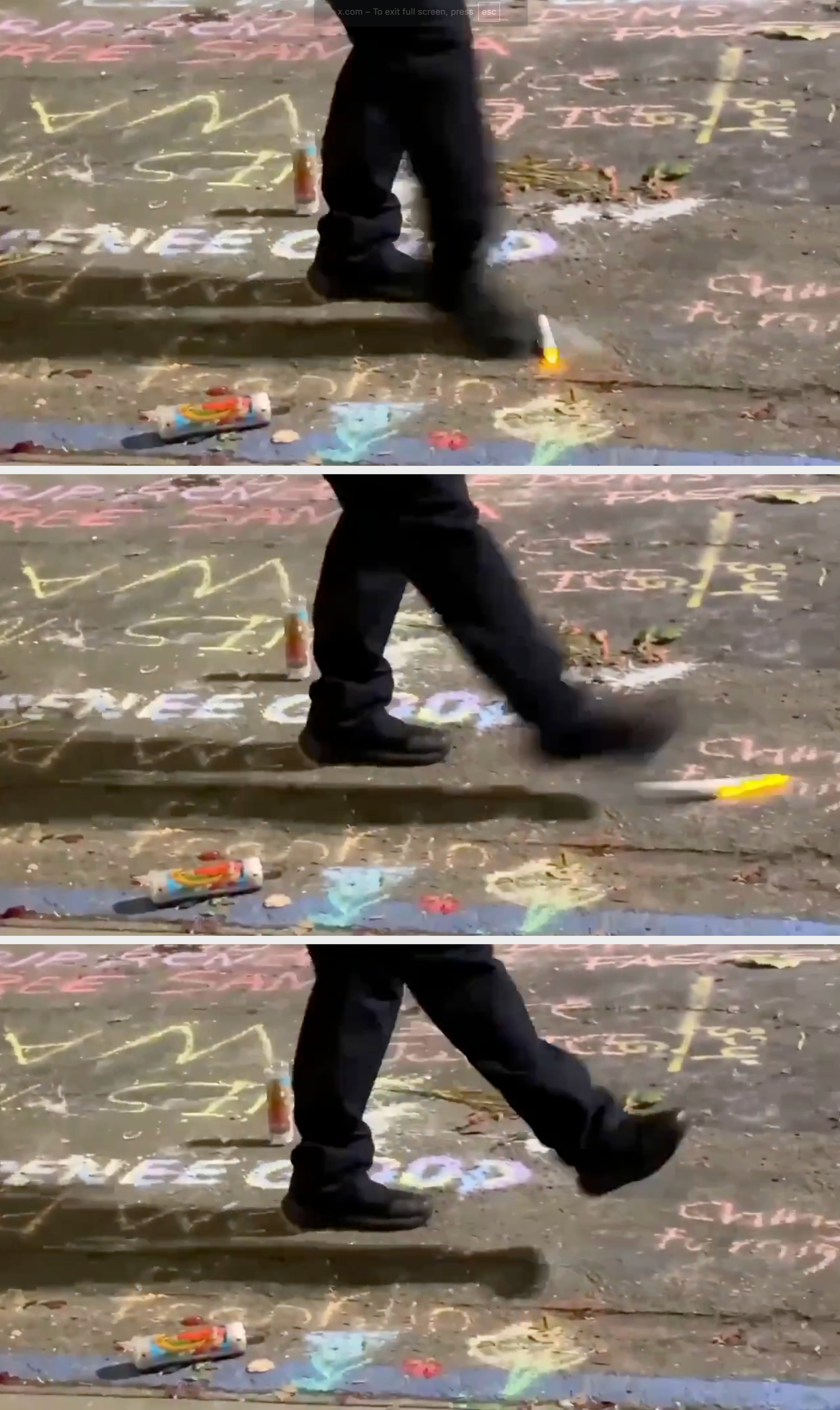 Person som går over et fortau dekket av kritttegninger og meldinger