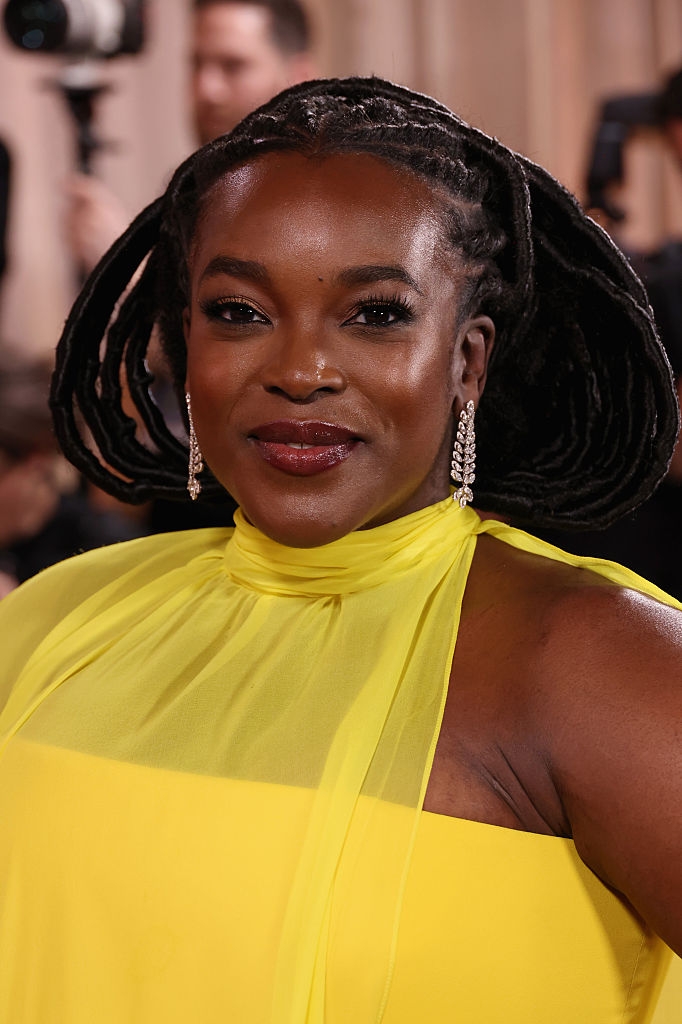 Person successful  elegant yellowish  gown with connection    earrings astatine  a ceremonial  event. Hair styled successful  agelong  braids