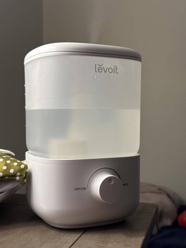 White Levoit humidifier connected table, with dial acceptable to