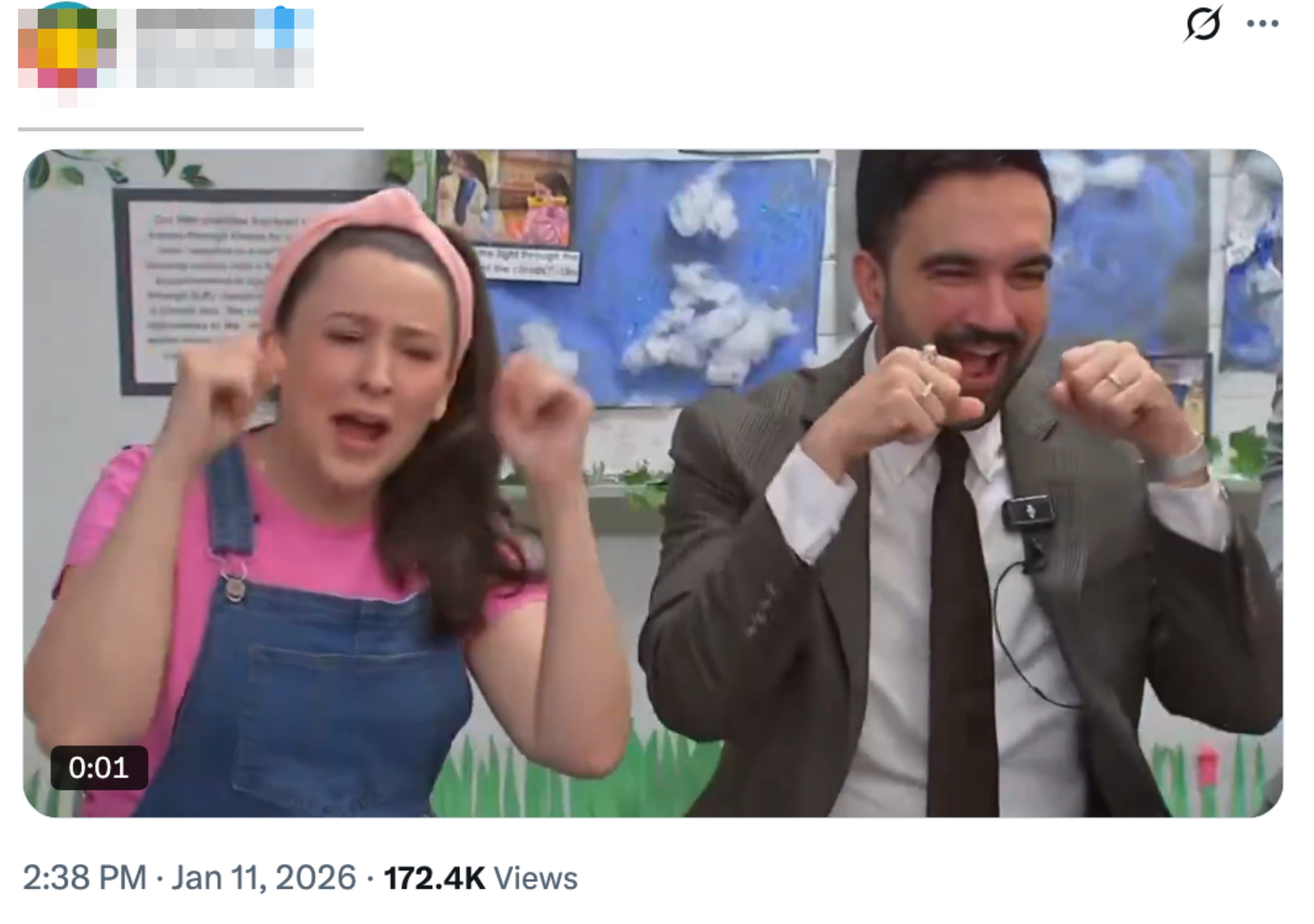 To personer som entusiastisk gestikulerer i en mediesetting, den ene har dress, den andre i rosa topp og kjeledress