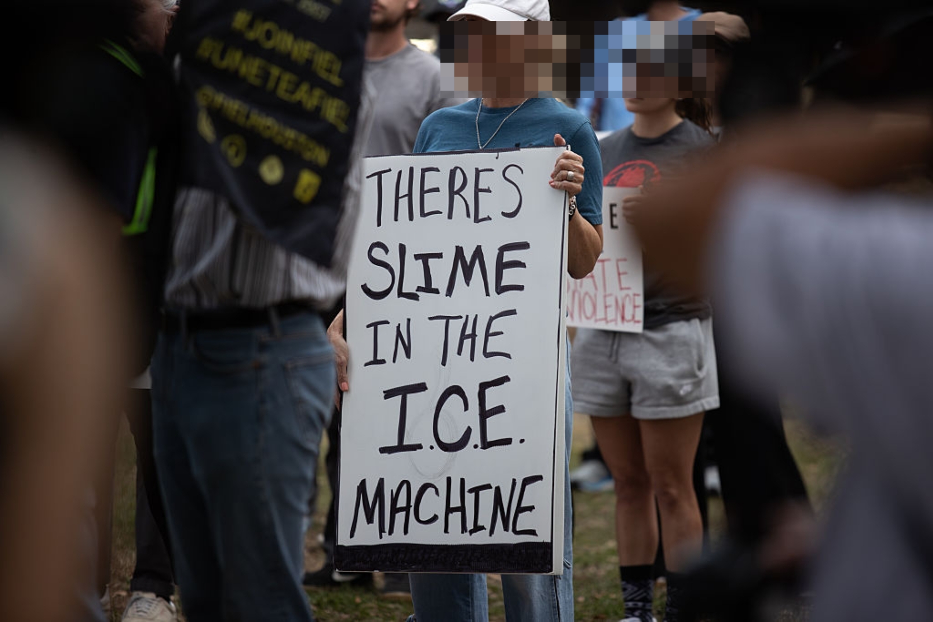 En person ved en protest holder et skilt med teksten 