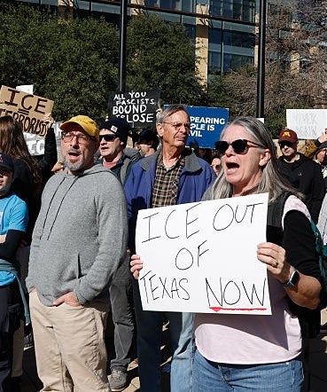 Folk ved en protest holder skilt med teksten 