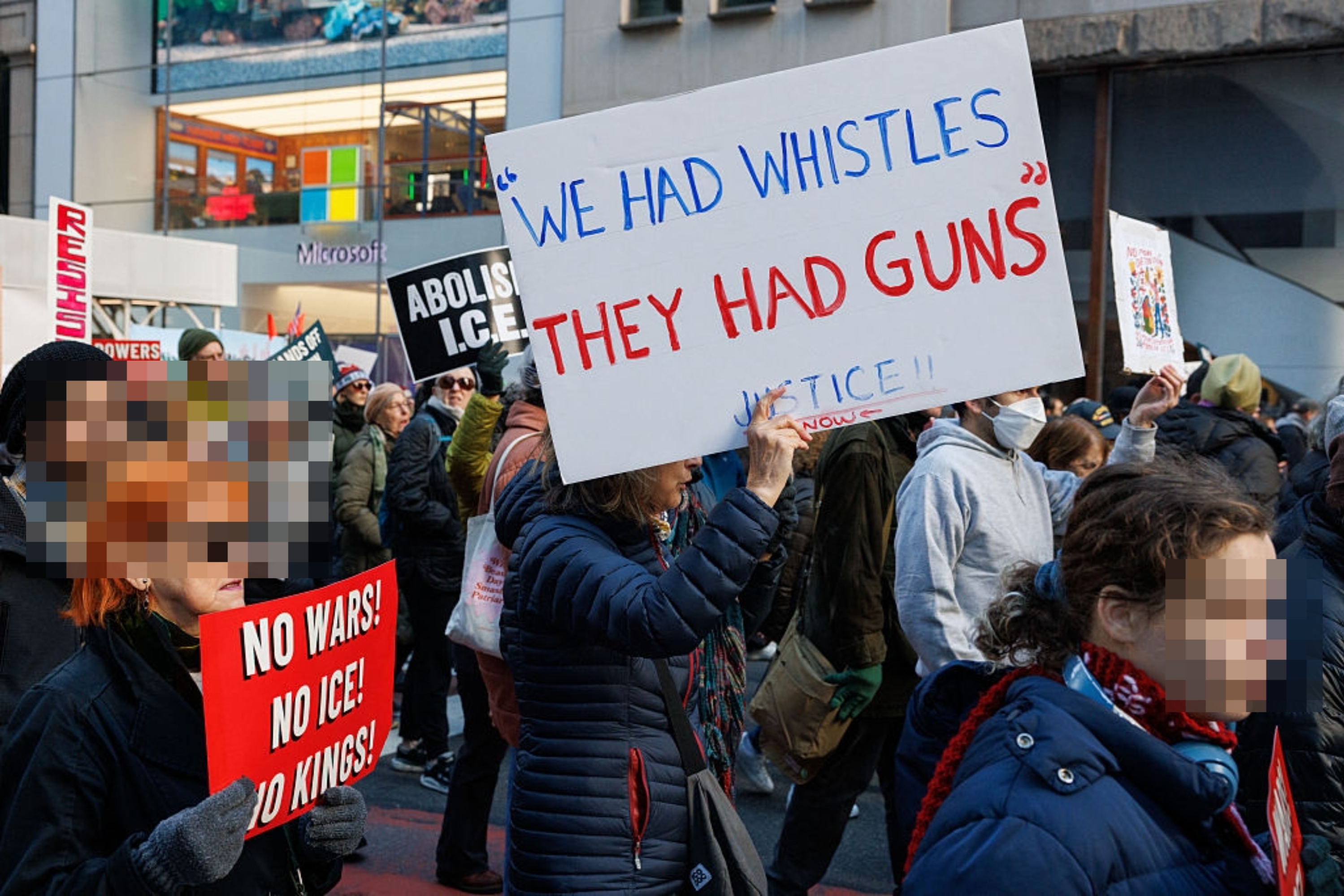 Folk i en protest holder skilt, inkludert et som sier 