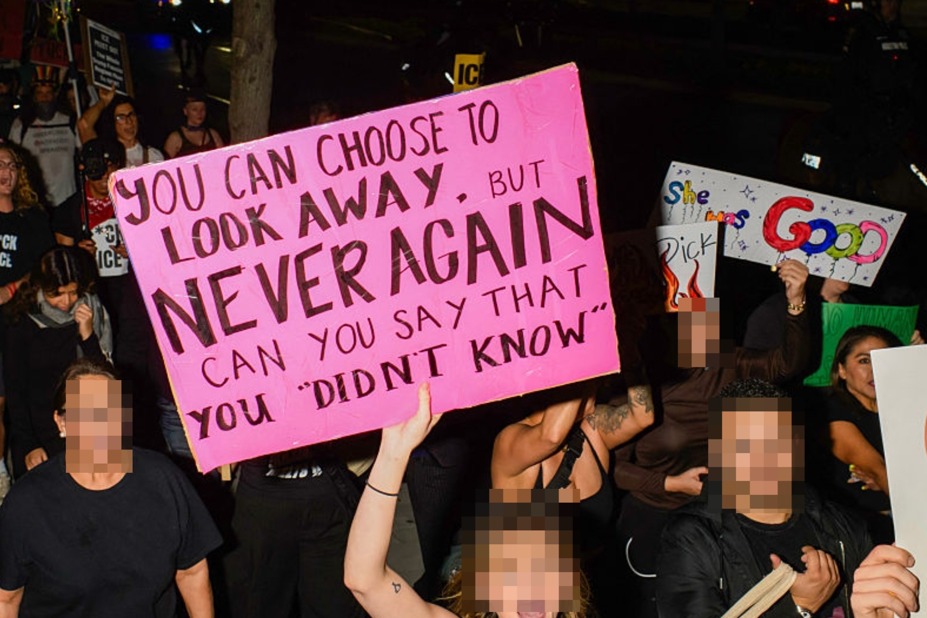 Demonstranter marsjerer med skilt med meldinger inkludert 