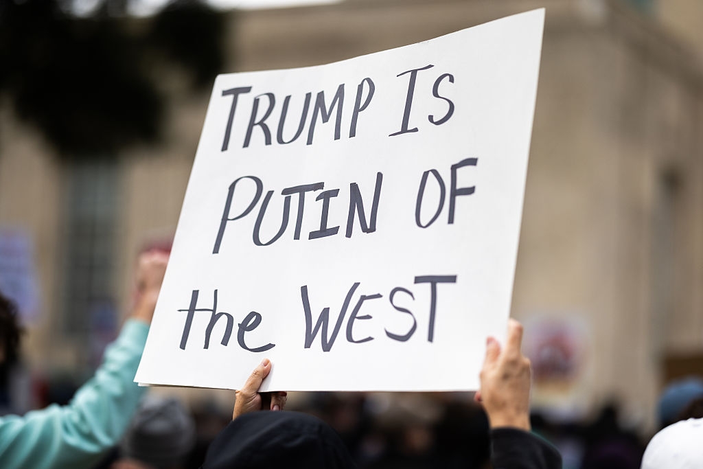 Personen holder et protestskilt som sier: 