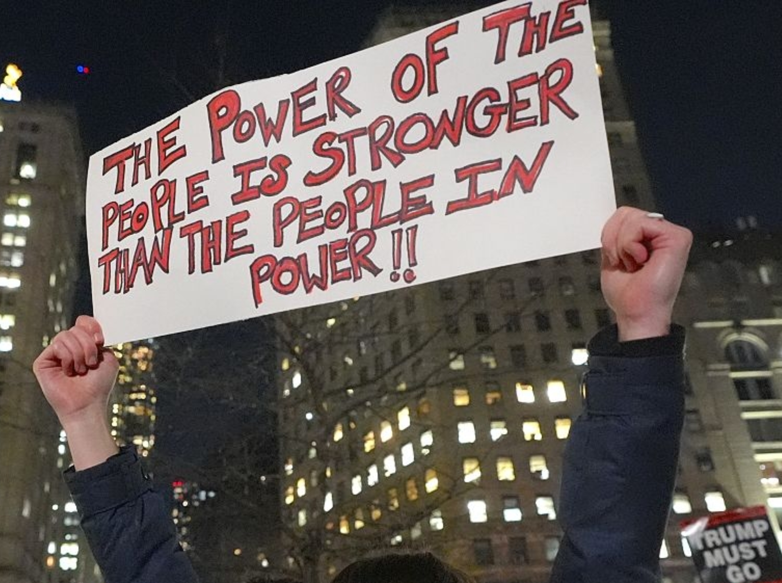 Person som holder et protestskilt med teksten 