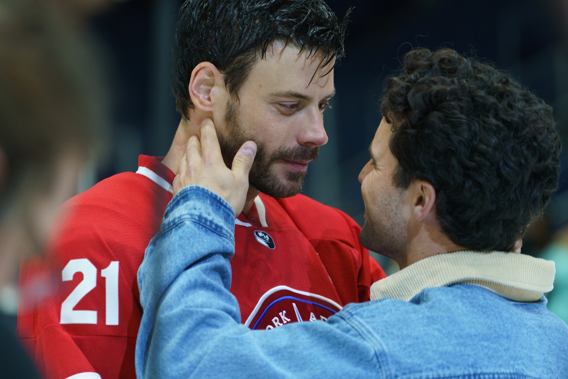 Two men sharing a adjacent moment, 1 successful a hockey jersey and the different successful a denim jacket, conveying relationship oregon affection
