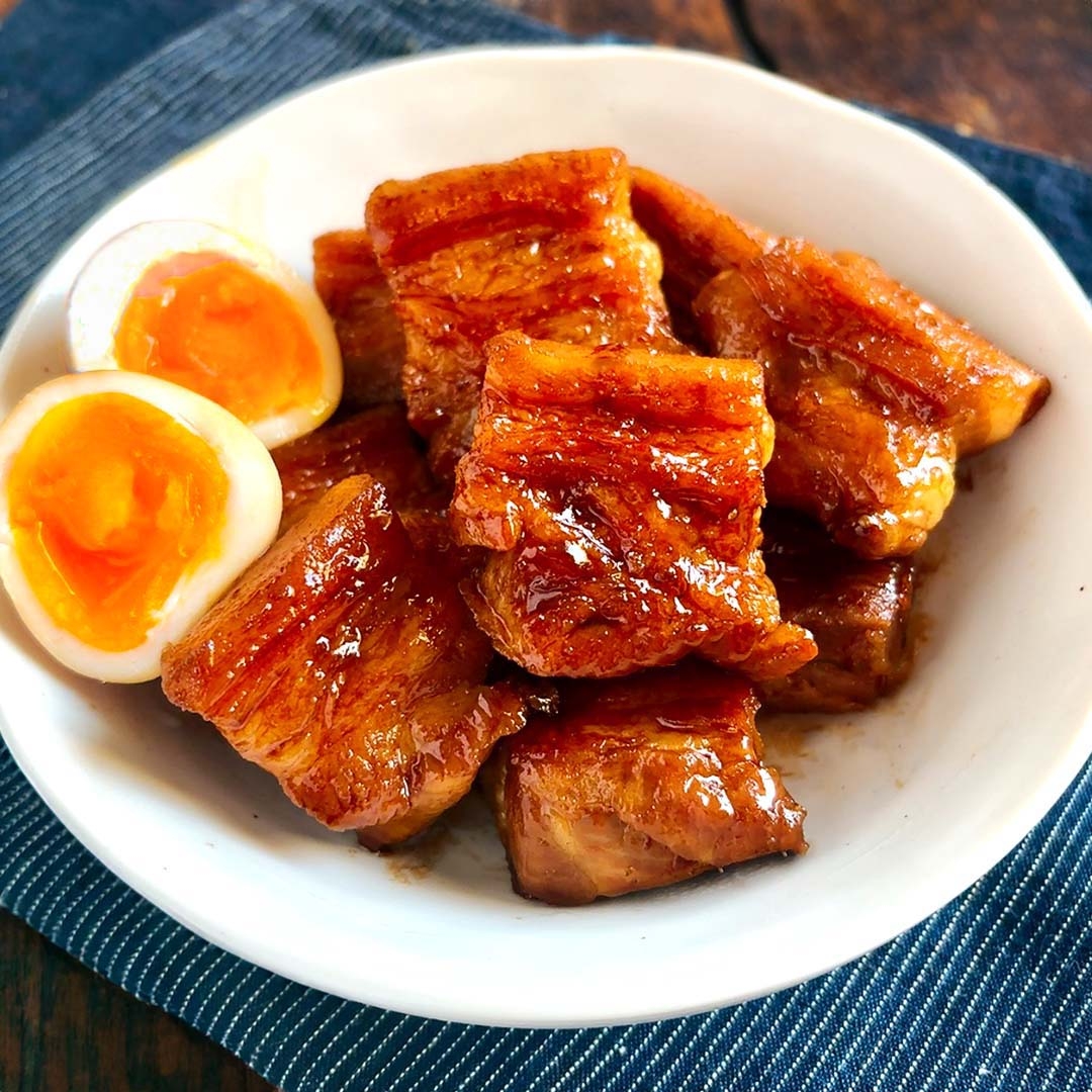 器に盛られた角煮と煮卵。料理は照りがあり、美味しそうに盛り付けられている。