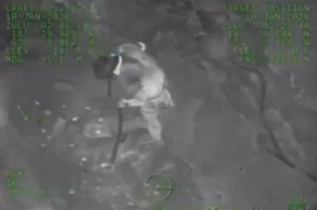 上空から撮影されたグレースケールの夜間映像で、人が棒状のものを持って移動しています。背景にデータ表示があります。