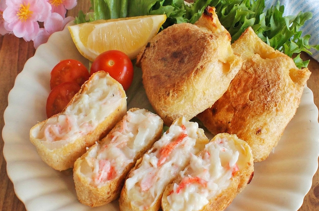 皿に盛られた揚げた食品とトマト、レタス、レモンが添えられている料理の写真。