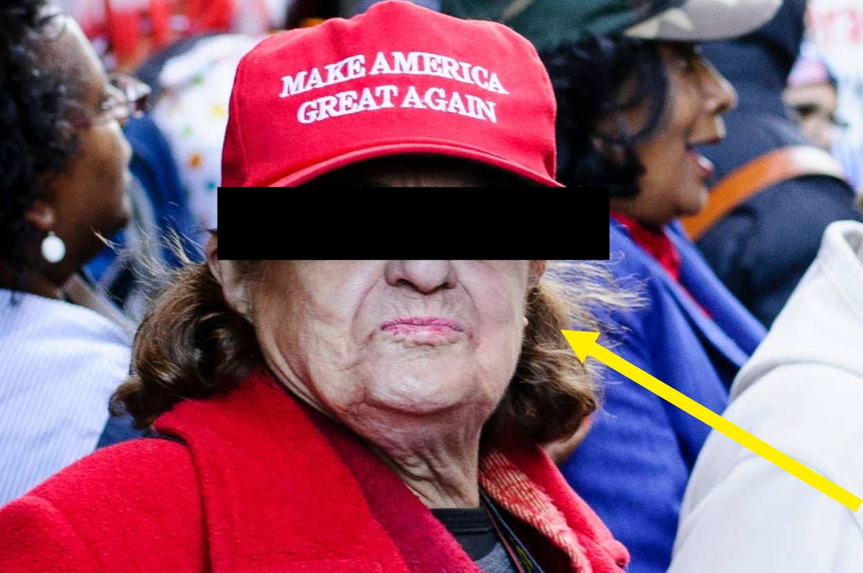 A person in a suit and red tie speaks animatedly at a podium with U.S. flags in the background
