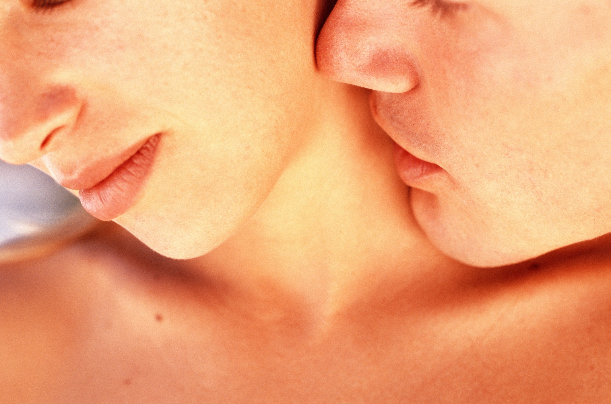 Close-up of a couple embracing intimately, focusing on their faces and necks, conveying a sense of affection and closeness