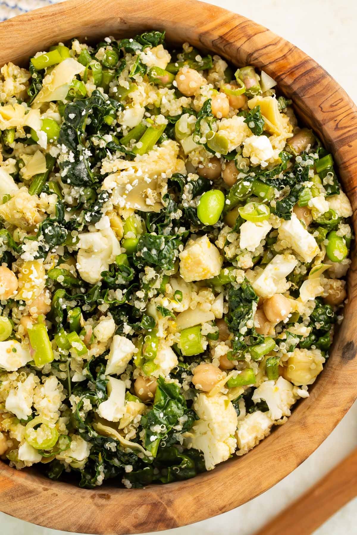 Bowl of quinoa salad with kale, chickpeas, edamame, and feta cheese
