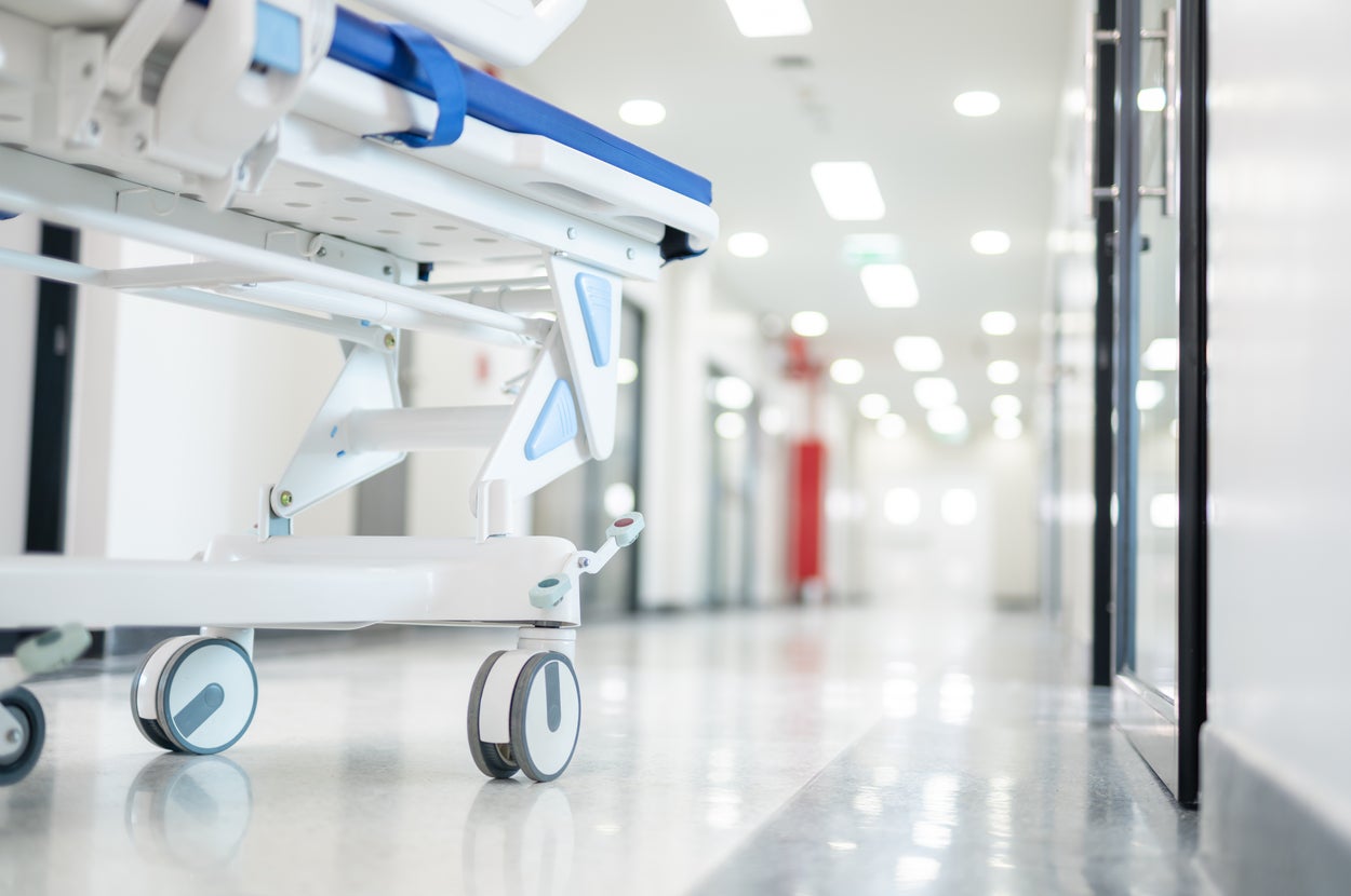 病院の廊下に停められた医療用ベッド。奥には明るく長い通路が見える。