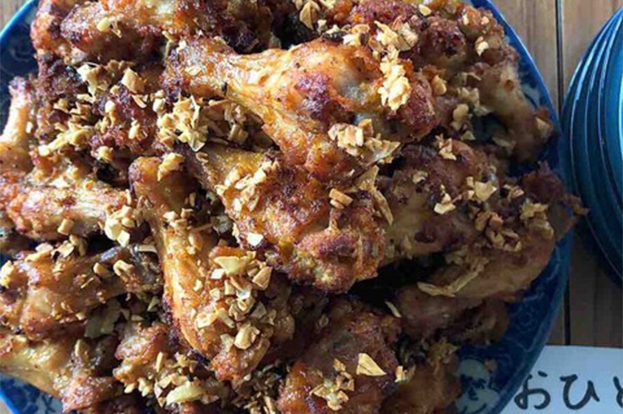 お皿に盛られた鶏の手羽先の唐揚げ。隣に「おひとり様6本まで」と書かれた紙。