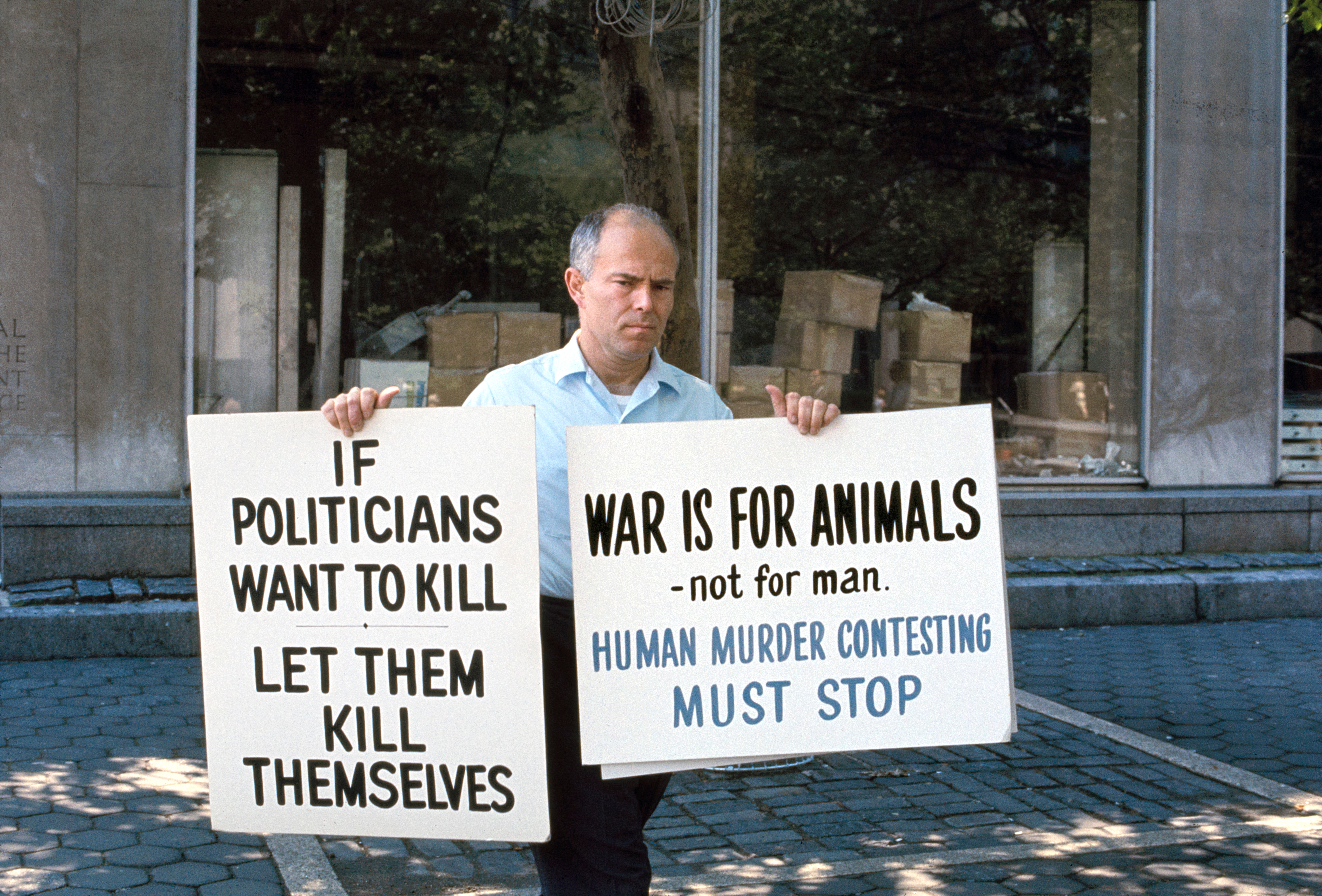 A antheral   holds protestation  signs reading, "If politicians privation  to kill, fto  them termination  themselves" and "War is for animals—not for man. Human execution  contesting indispensable   stop."