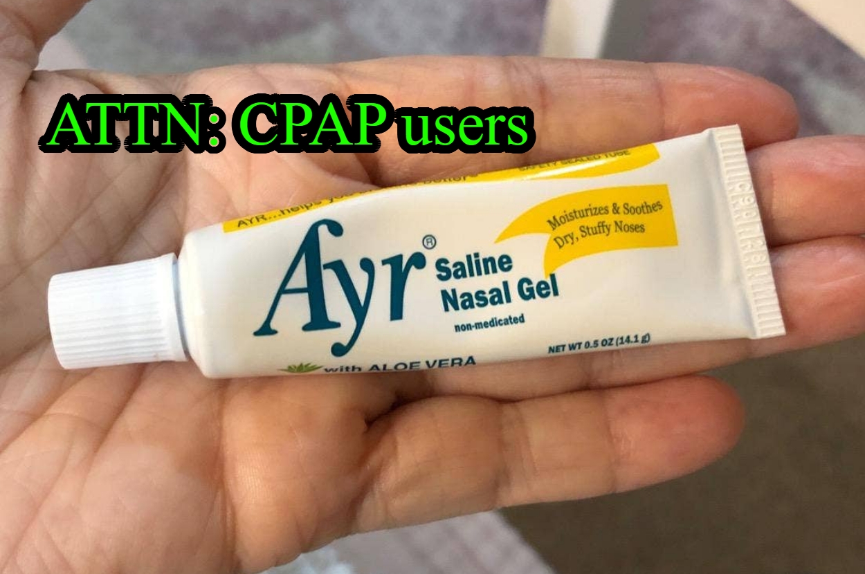 Hand holding a tube of Ayr Saline Nasal Gel, labeled for CPAP users; moisturizes and soothes dry, stuffy noses