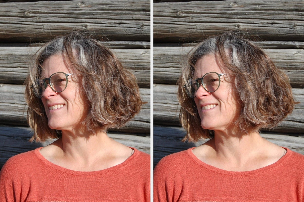Person with round glasses and a bob haircut smiling outdoors in front of a wooden wall