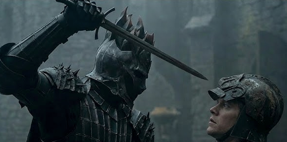 A knight in dark armored helmet threatens another knight with a sword in a medieval setting