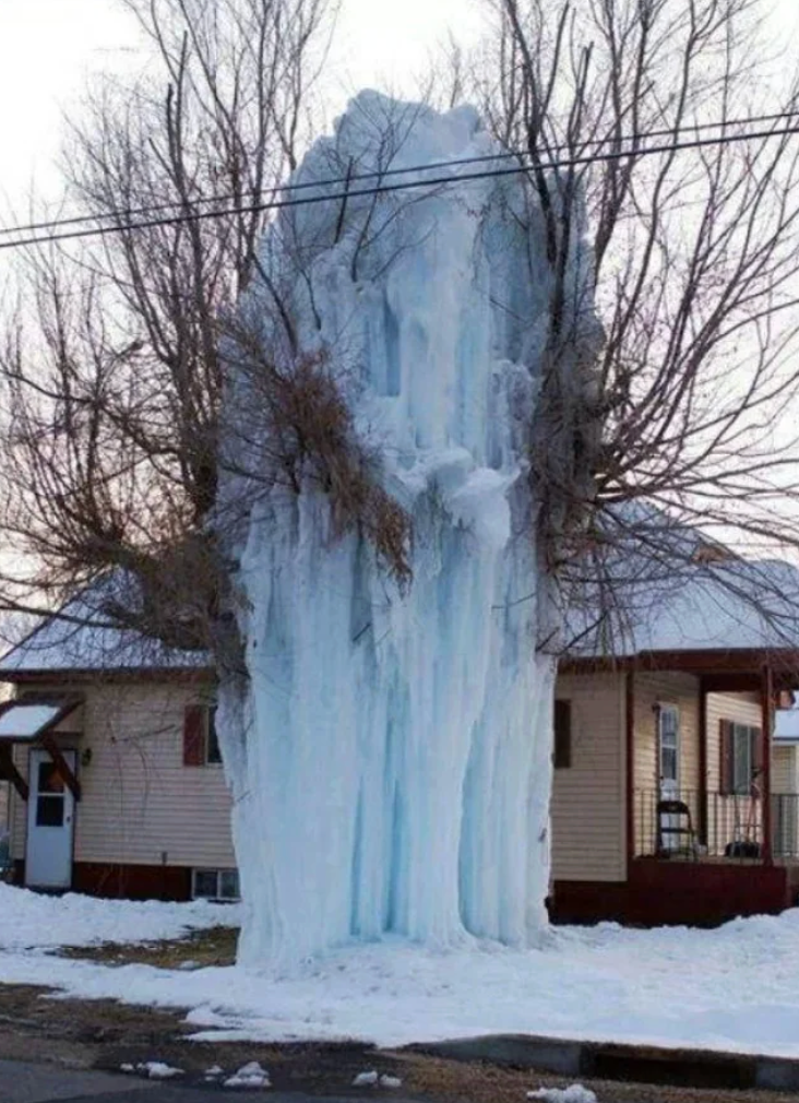 Ice covers a histrion successful beforehand of a house, creating a ample frozen waterfall-like structure