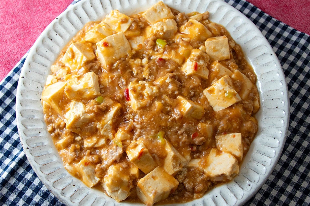 皿に盛られた麻婆豆腐。豆腐とひき肉がとろりとしたソースで絡められ、香辛料で味付けされている。
