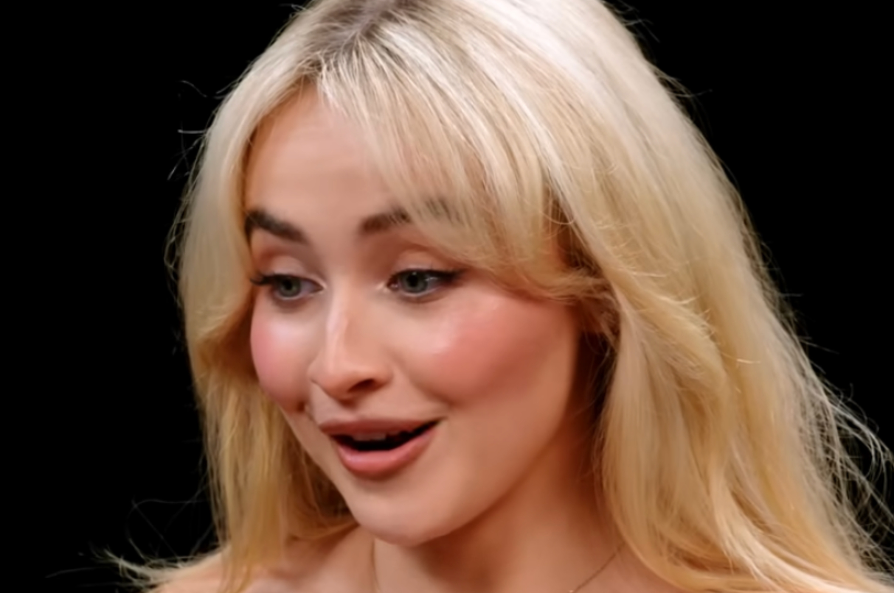 Person with long hair smiles and looks surprised