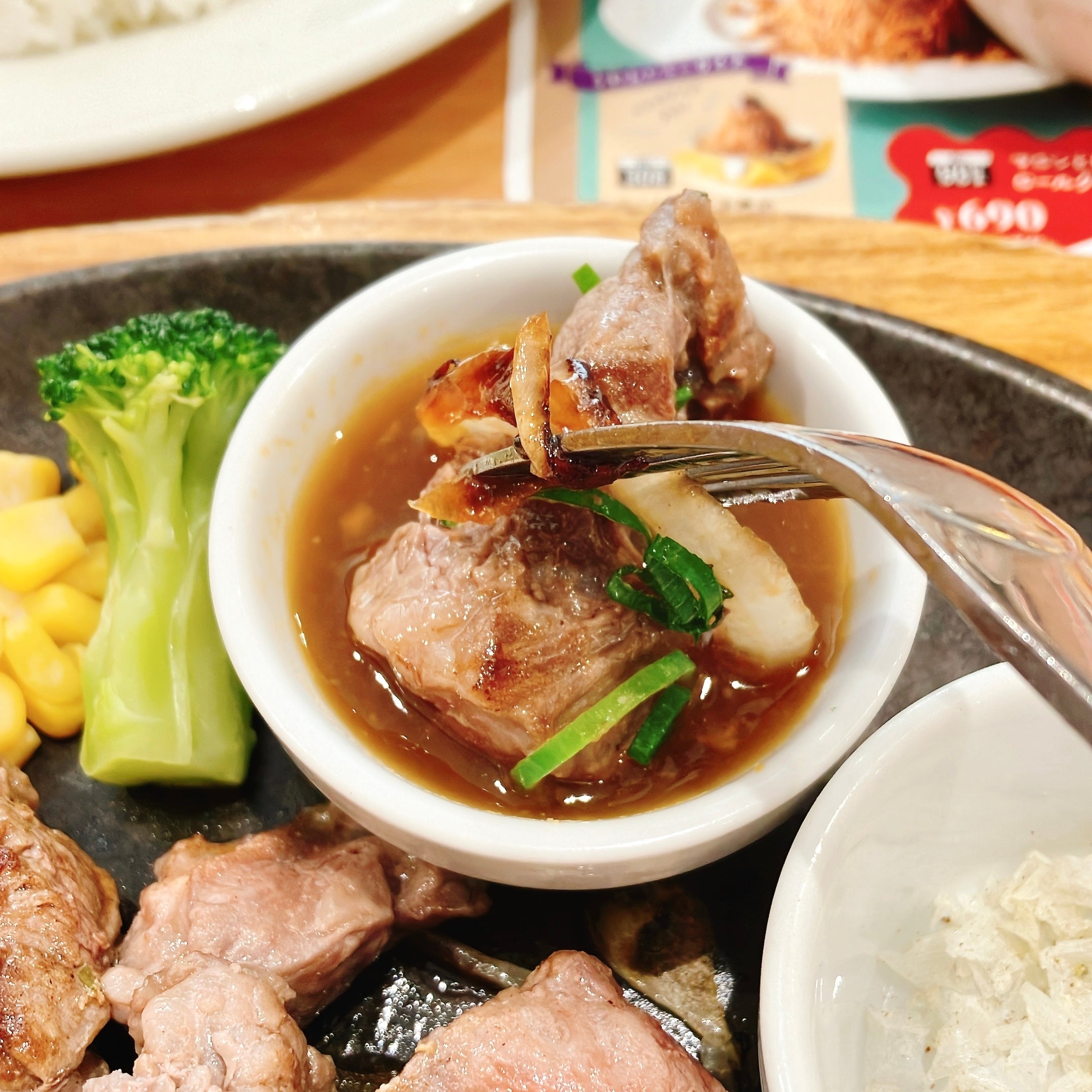 ココスの「カットステーキ 130g」ソースにステーキをディップしている様子。