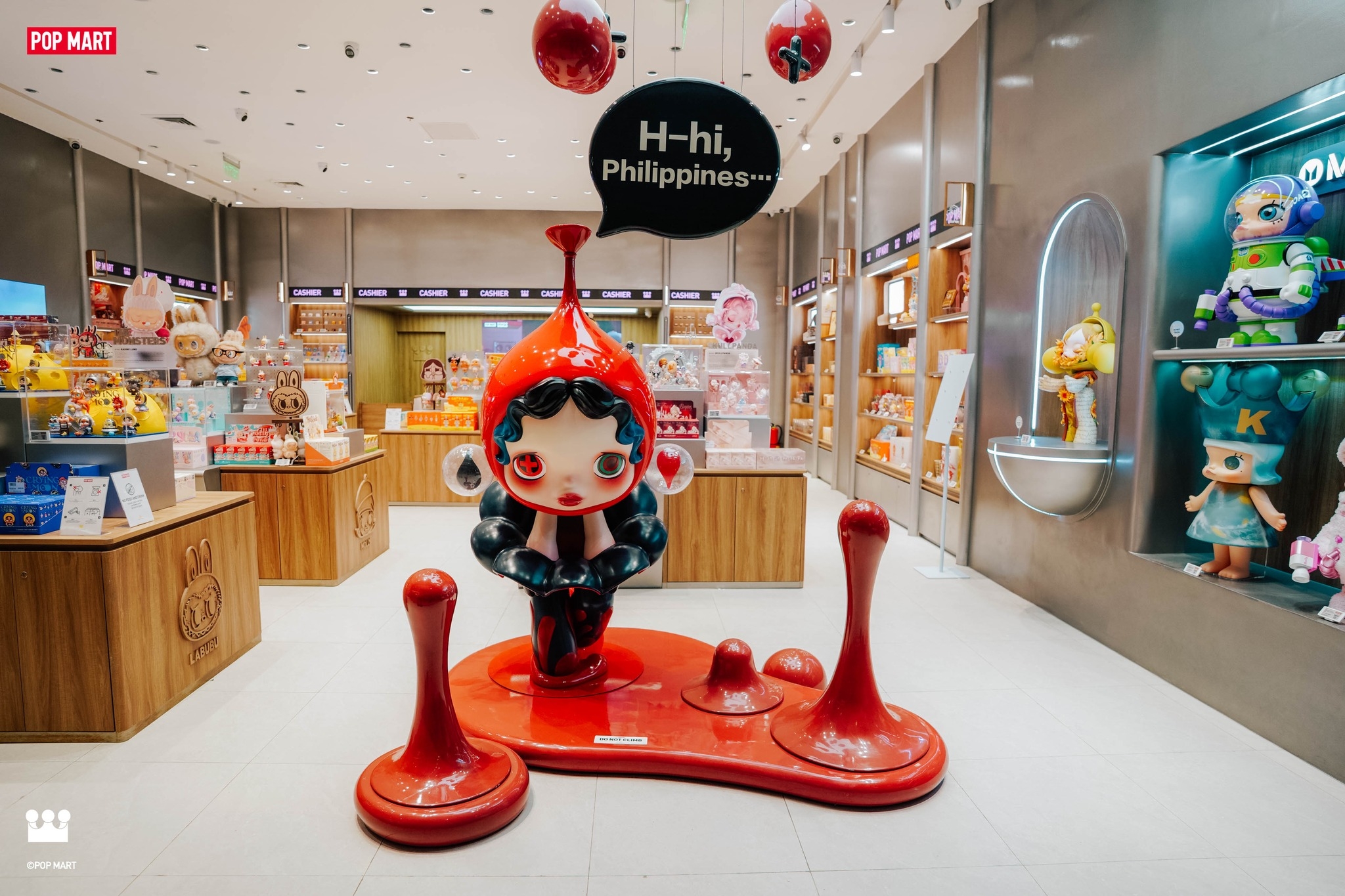 Toy store display with a large, cartoonish figure wearing a red and black outfit. A speech bubble reads, "H-hi, Philippines..."