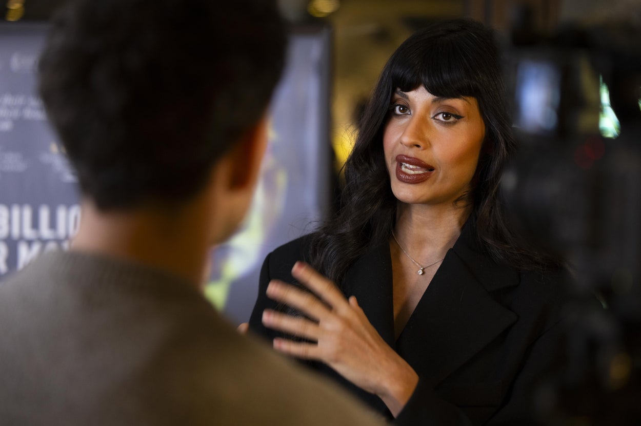 Jameela Jamil in a blazer speaking and gesturing during an interview on the red carpet