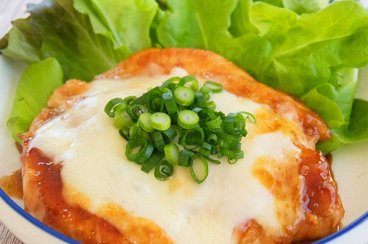 焼肉のたれで焼いた鶏むね肉に、とろけたチーズと刻んだネギがのった料理。