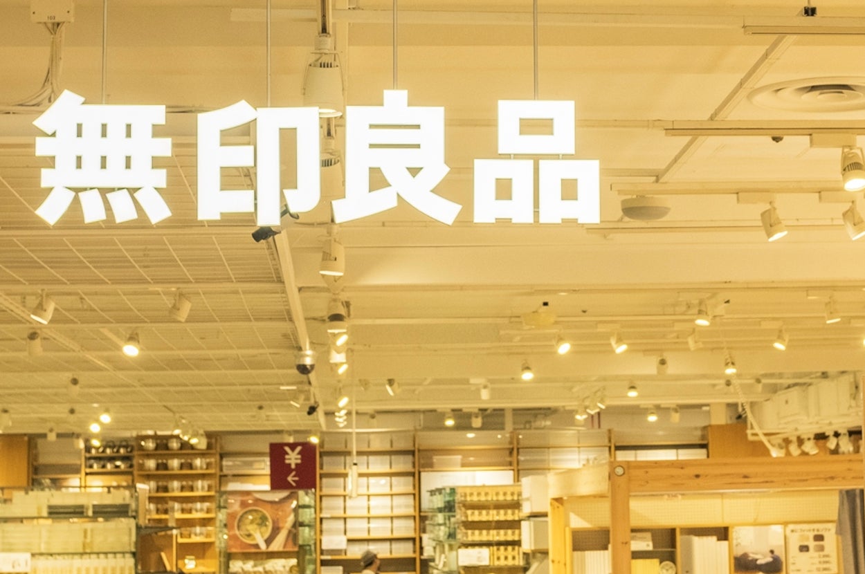 People shopping inside a well-lit Muji store, filled with various home goods and products