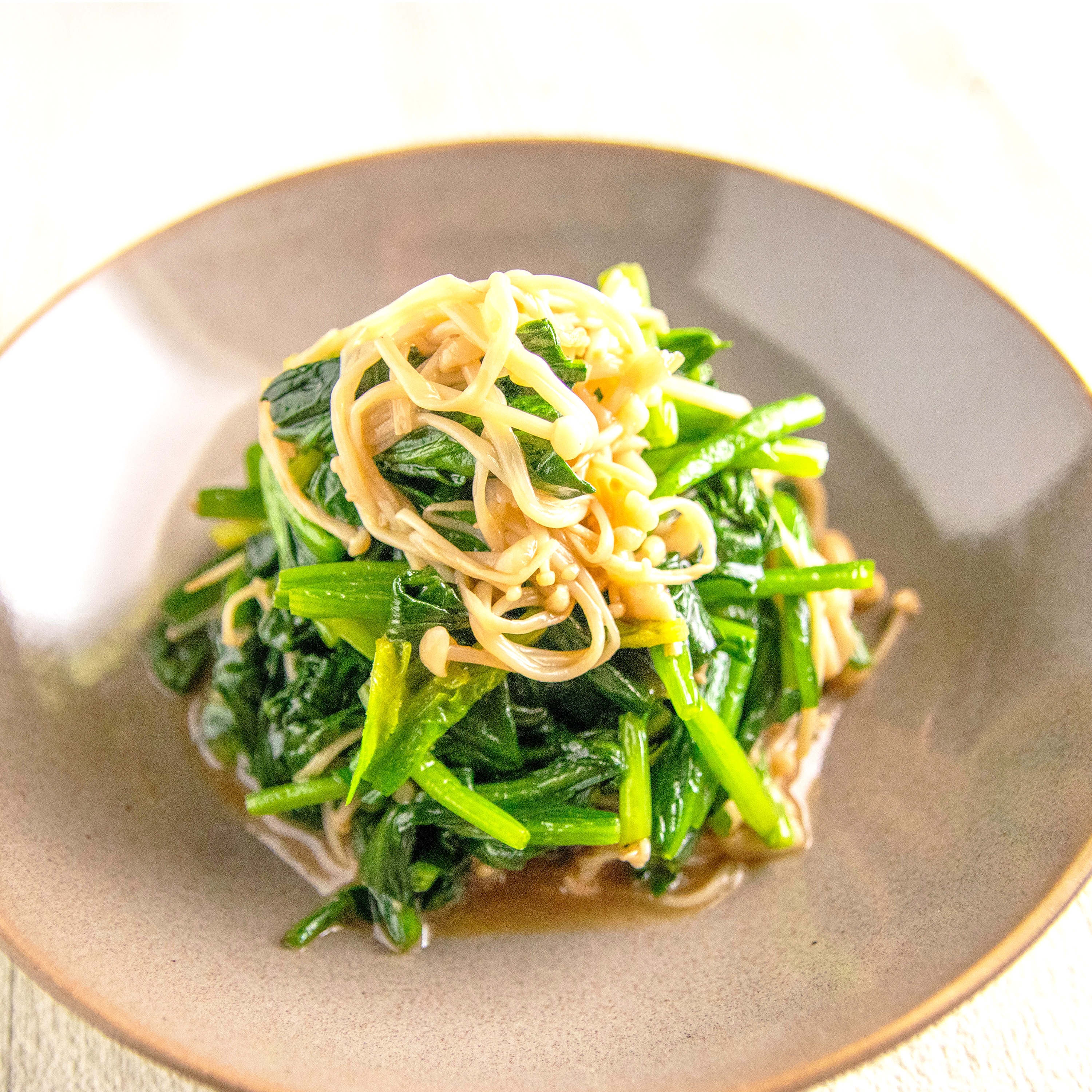 お皿に盛られたほうれん草とえのき茸の和え物、彩り豊かで軽やかな料理。