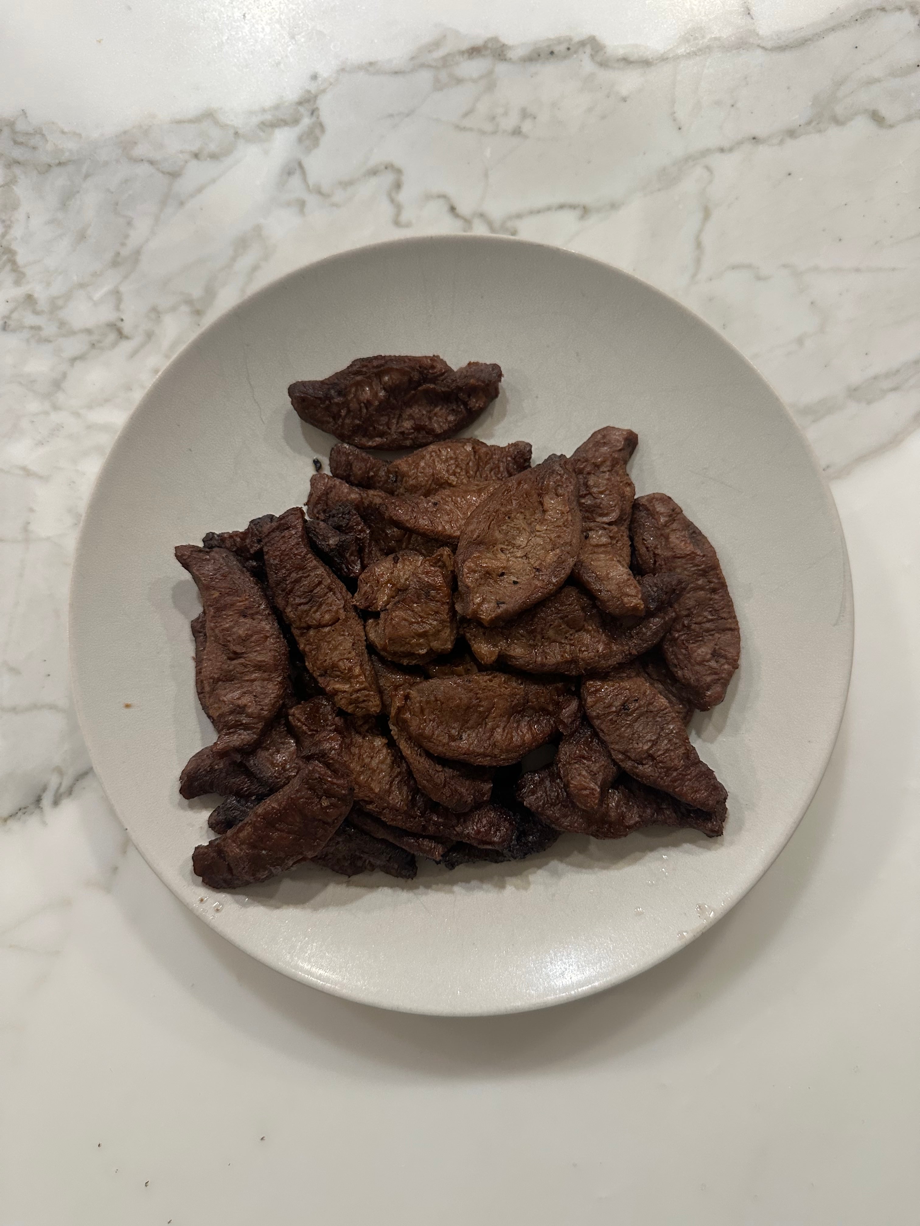 A white plate filled with strips of meatless bulgogi
