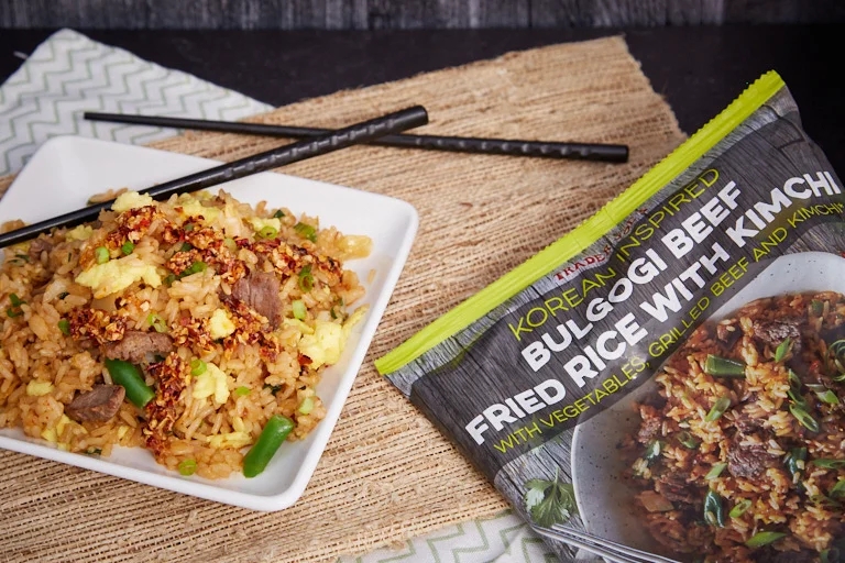 Plate of Korean-inspired bulgogi beef fried rice next to a package with the same dish pictured