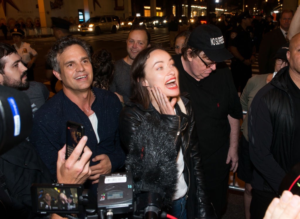 Group of radical   smiling and chatting amidst a assemblage  astatine  a nighttime event, immoderate   wearing casual jackets and hats