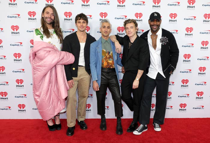 Group of five people standing on a red carpet; styles include casual, chic, and trendy outfits