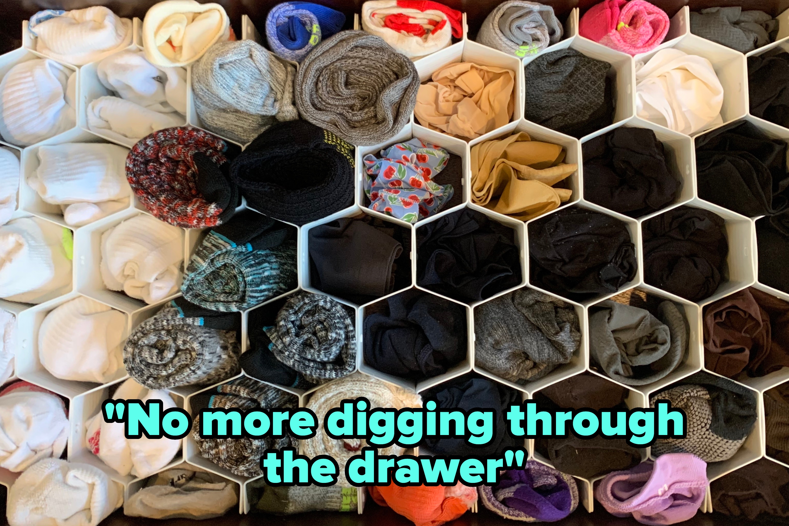 a drawer with honeycomb-shaped organizers filled with socks and reviewer text "No more diffing through the drawer"