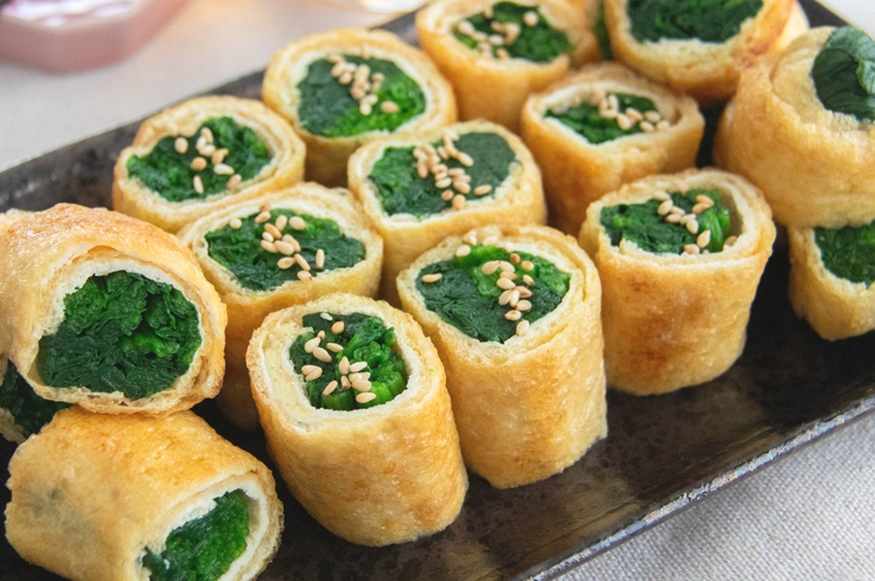 お皿にのったほうれん草の油揚げ巻き。白いりごまがトッピングされている。