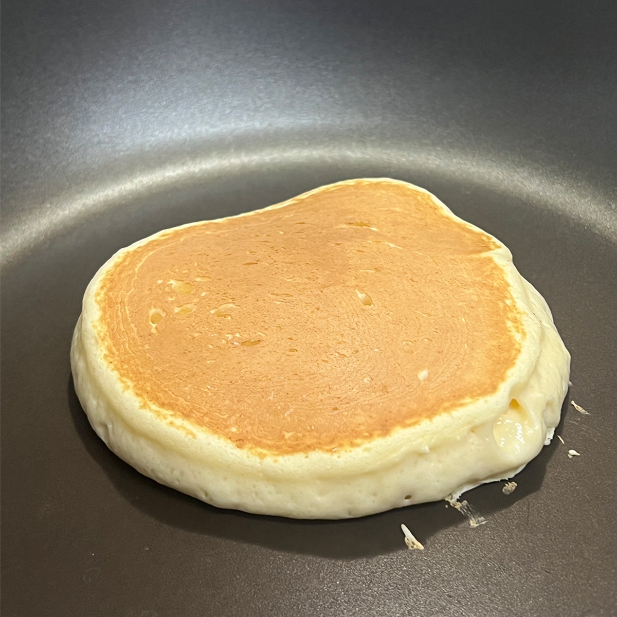 フライパンで焼かれているパンケーキ。厚みがあり、ふんわりとした仕上がりが特徴。