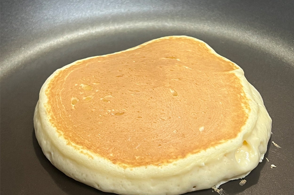 フライパンで焼かれているパンケーキ。厚みがあり、ふんわりとした仕上がりが特徴。