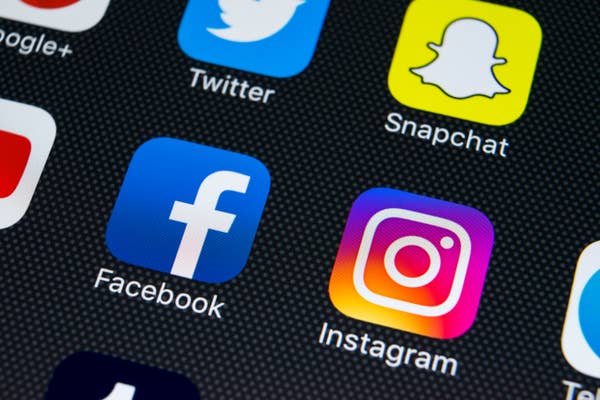Smartphone screen displaying social media app icons: Twitter, Snapchat, Facebook, and Instagram