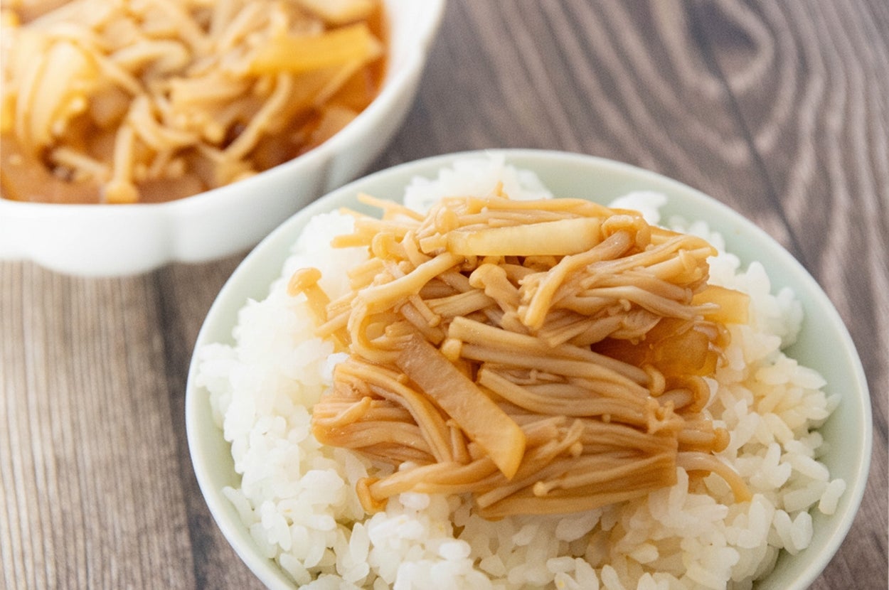 なめたけがトッピングされたご飯の丼がテーブルに置かれている。