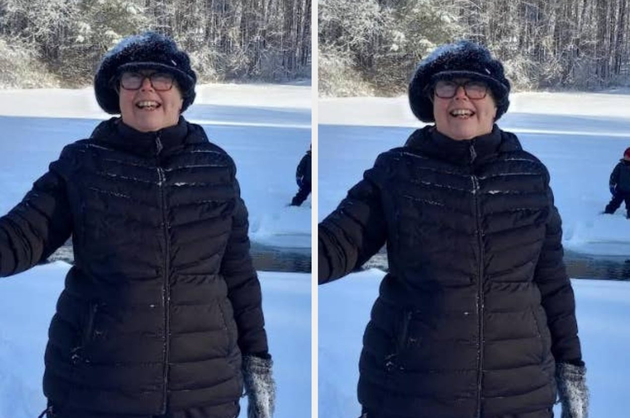 A person in winter attire smiles outdoors in a snowy landscape, enjoying a day by a frozen lake with others in the background